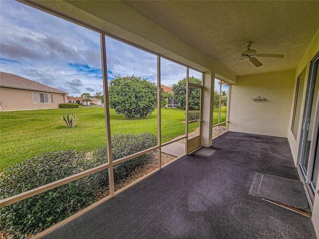 unfurnished sunroom featuring ceiling fan