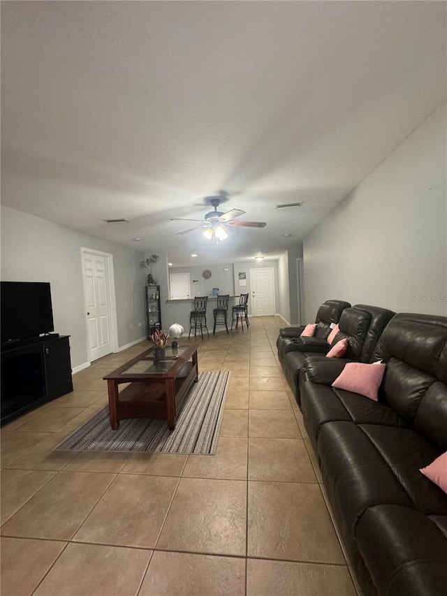 living room with ceiling fan and light tile patterned flooring