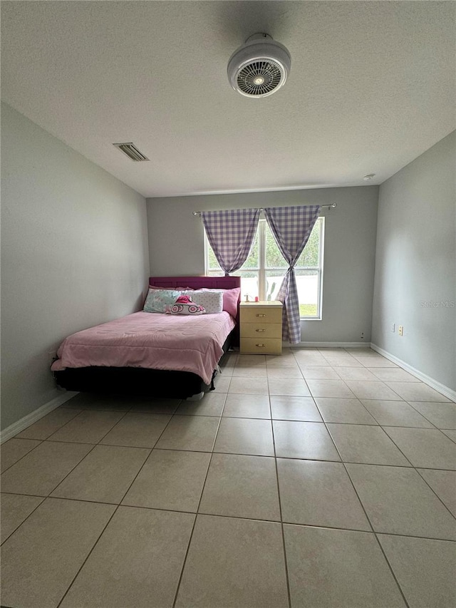 unfurnished bedroom featuring a textured ceiling and light tile patterned floors