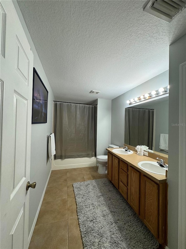 full bathroom with vanity, toilet, tile patterned floors, and a textured ceiling