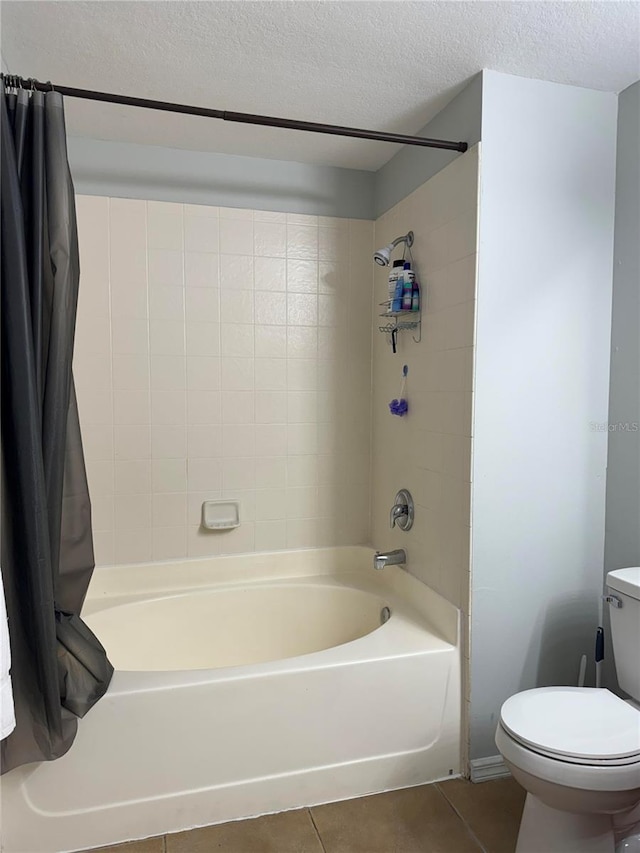 bathroom with shower / bath combination with curtain, tile patterned flooring, toilet, and a textured ceiling