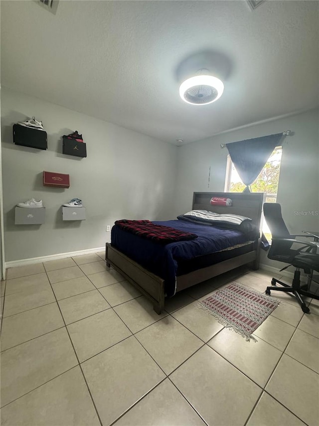 bedroom with a textured ceiling and tile patterned floors