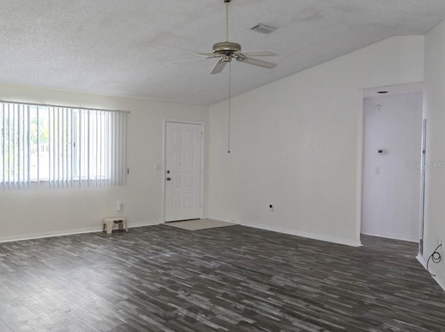 spare room featuring a textured ceiling, lofted ceiling, dark wood-type flooring, and a ceiling fan