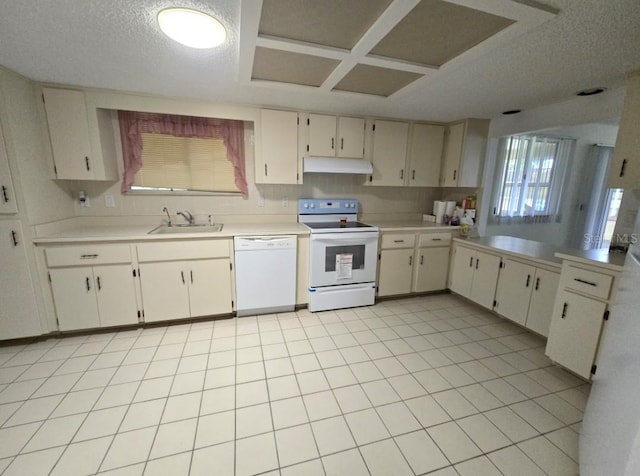kitchen featuring a textured ceiling, light countertops, white appliances, under cabinet range hood, and a sink