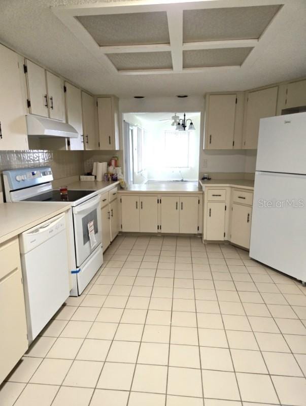 kitchen featuring white appliances, light countertops, under cabinet range hood, and light tile patterned floors