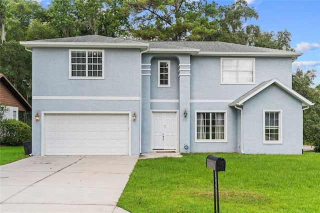 view of property with a garage and a front lawn