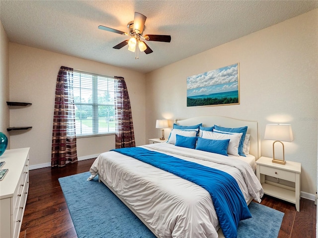 bedroom with a textured ceiling, ceiling fan, and dark wood-type flooring