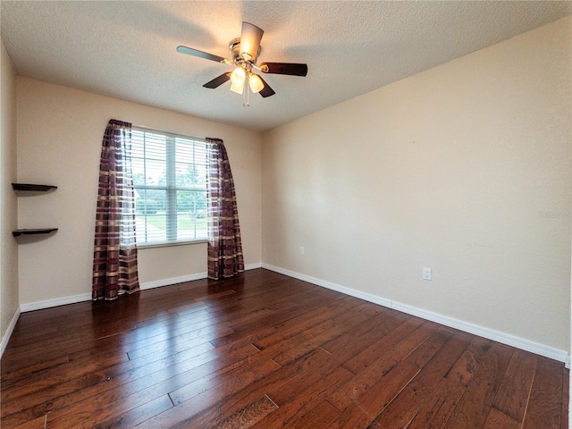 empty room featuring ceiling fan, dark wood-type flooring, and a textured ceiling