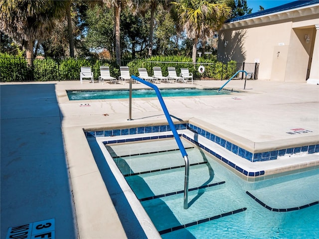 view of pool with a patio area and a hot tub