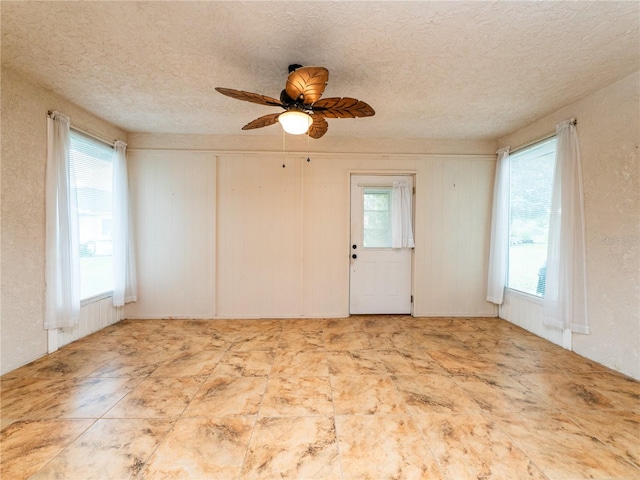 spare room with ceiling fan and a textured ceiling