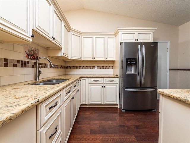 kitchen with lofted ceiling, backsplash, dark wood-type flooring, sink, and stainless steel refrigerator with ice dispenser