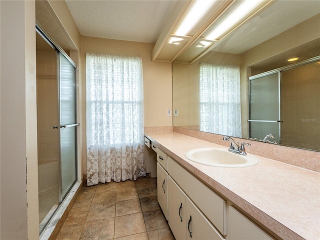 bathroom with vanity, a healthy amount of sunlight, and a shower with shower door