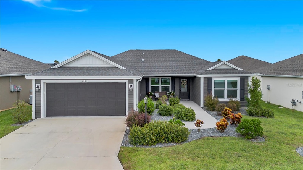 single story home with a garage and a front lawn