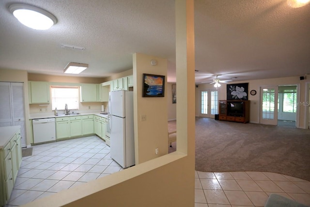 kitchen with white appliances, sink, light tile patterned flooring, ceiling fan, and a textured ceiling