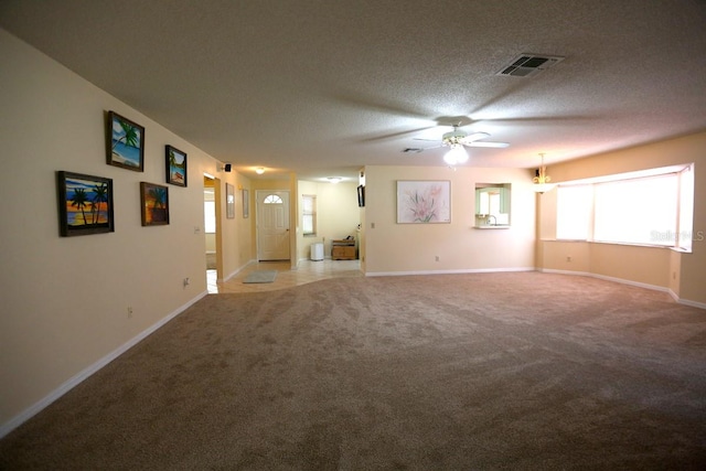 carpeted empty room featuring ceiling fan and a textured ceiling