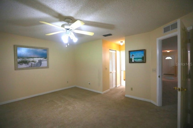 interior space with a textured ceiling, carpet flooring, ceiling fan, and a closet