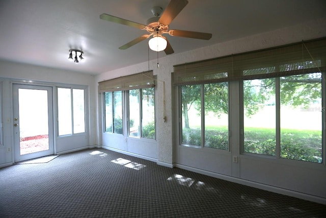 unfurnished sunroom featuring ceiling fan