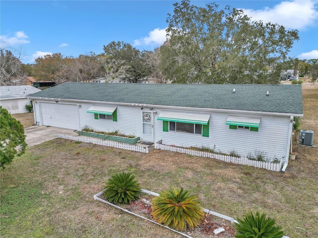 ranch-style house featuring cooling unit, a garage, and a front lawn