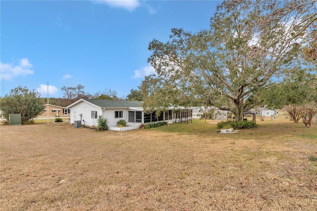 view of yard with central AC and a sunroom