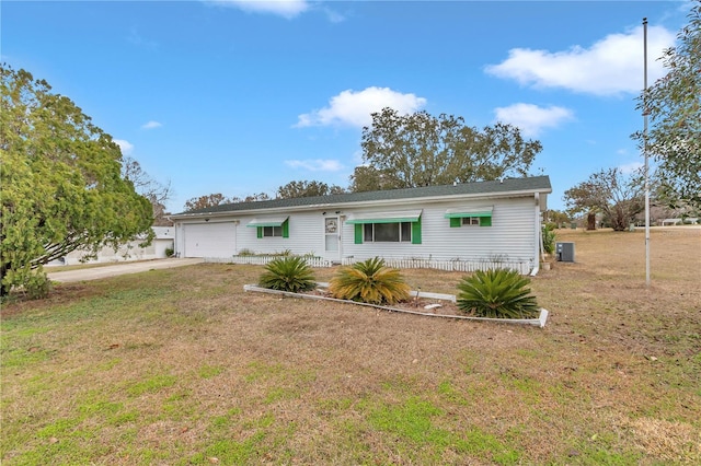 view of front of house with a garage, a front yard, and central air condition unit