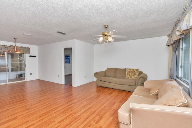 unfurnished living room with ceiling fan, wood-type flooring, and a textured ceiling