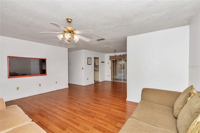 unfurnished living room with ceiling fan, wood-type flooring, and a textured ceiling