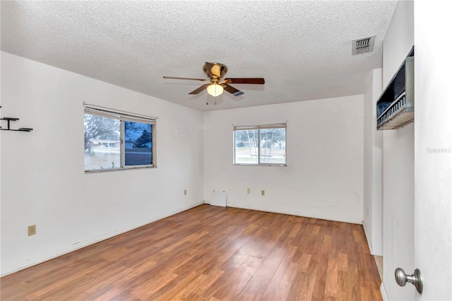 spare room featuring ceiling fan, hardwood / wood-style floors, and a textured ceiling