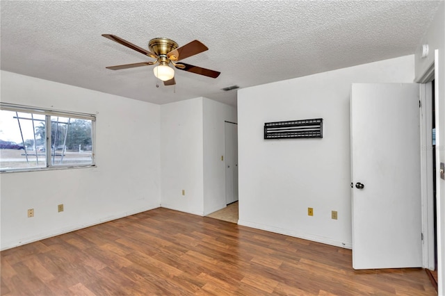 unfurnished room featuring ceiling fan, wood-type flooring, and a textured ceiling