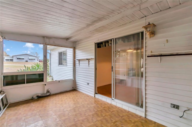 unfurnished sunroom with beamed ceiling and wood ceiling