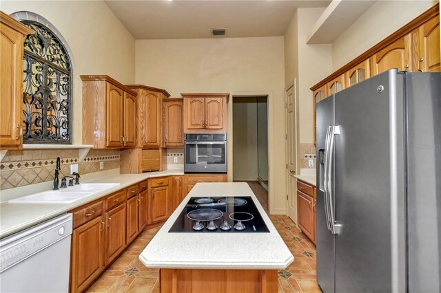 kitchen featuring a center island, sink, appliances with stainless steel finishes, and tasteful backsplash