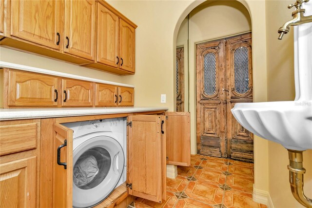 laundry area featuring cabinets, light tile patterned floors, and washer / clothes dryer