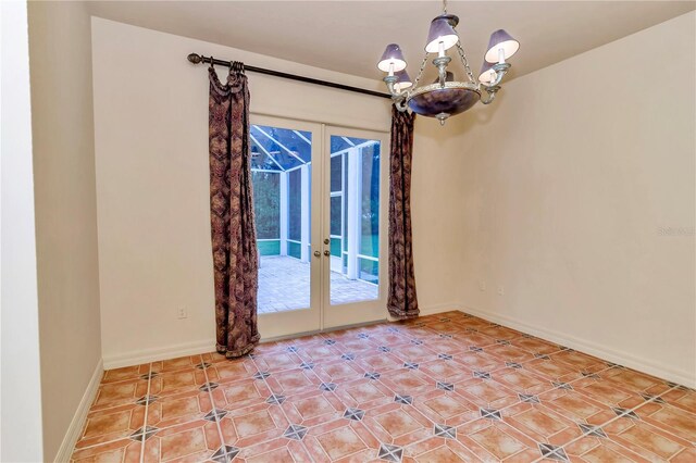 spare room featuring tile patterned floors, a chandelier, and french doors