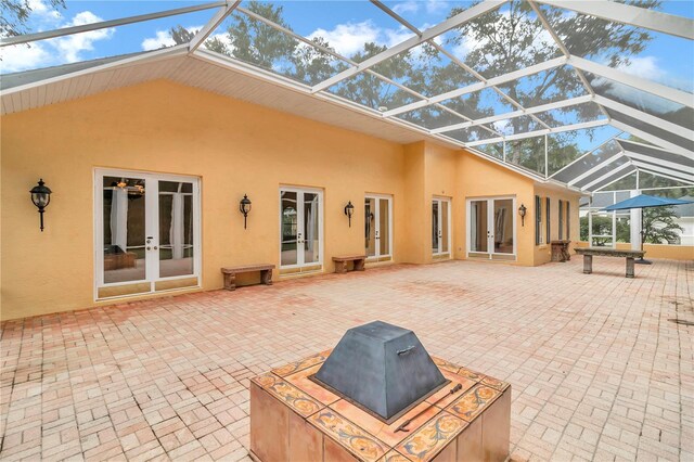 rear view of house featuring french doors, a lanai, and a patio area