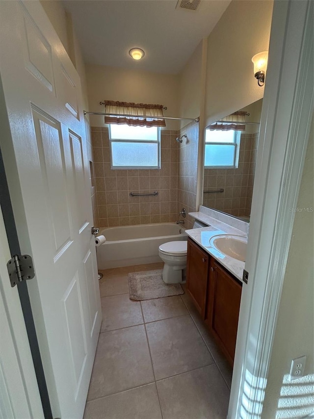 full bathroom with tile patterned floors, toilet, tiled shower / bath combo, and vanity