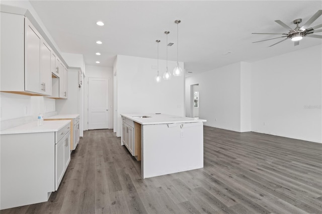 kitchen featuring pendant lighting, wood-type flooring, white cabinetry, and ceiling fan