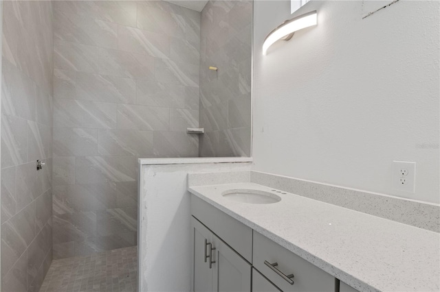 bathroom with vanity and a tile shower