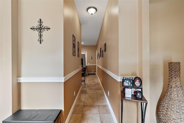 corridor with light tile patterned floors and a textured ceiling