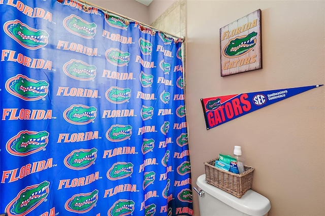 bathroom featuring toilet and curtained shower