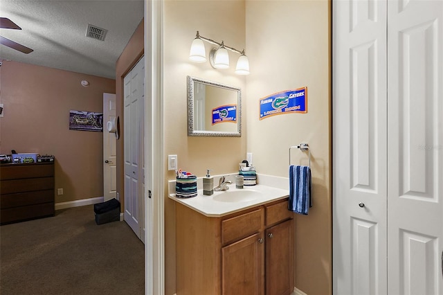 bathroom featuring a textured ceiling, vanity, and ceiling fan