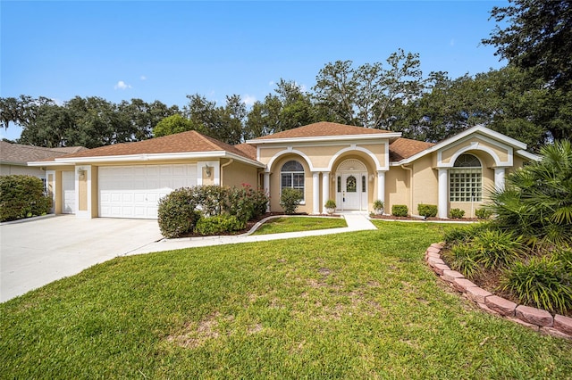 mediterranean / spanish house with a garage and a front lawn