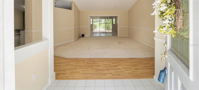 hall featuring light wood-type flooring and lofted ceiling