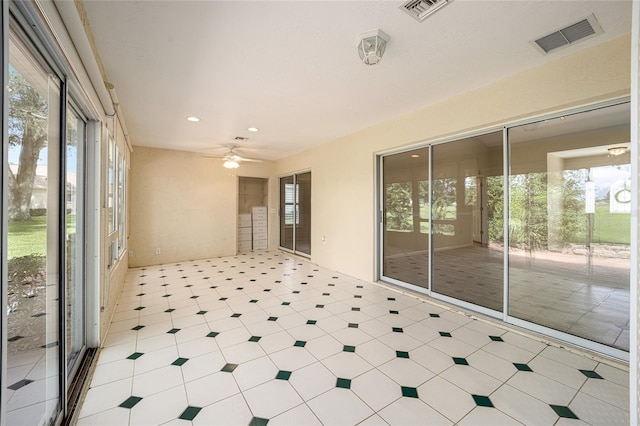 unfurnished sunroom with ceiling fan