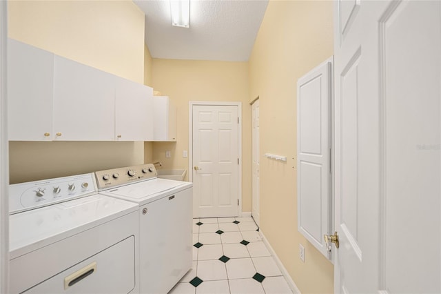 laundry room with cabinets, independent washer and dryer, and a textured ceiling