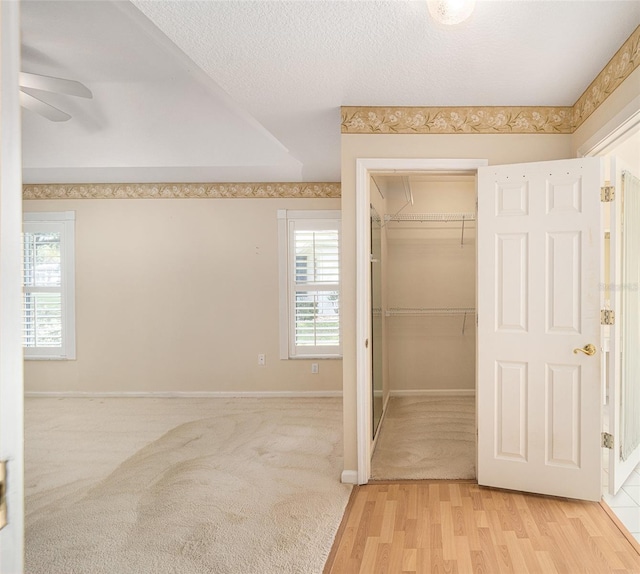 bathroom with a textured ceiling, hardwood / wood-style flooring, and ceiling fan