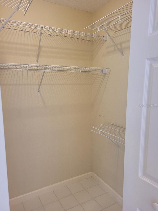 walk in closet with tile patterned floors