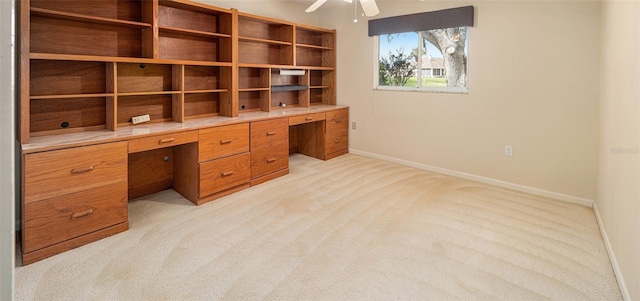 unfurnished office with ceiling fan and light carpet