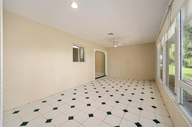 unfurnished sunroom featuring a wealth of natural light and ceiling fan