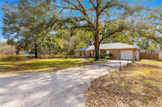 ranch-style home featuring a garage and a front lawn