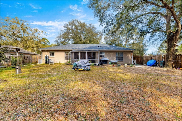 back of house with a yard and a sunroom