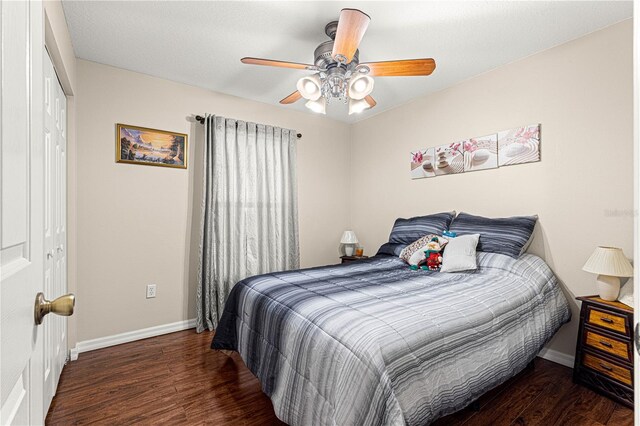 bedroom featuring dark wood-type flooring, ceiling fan, and a closet